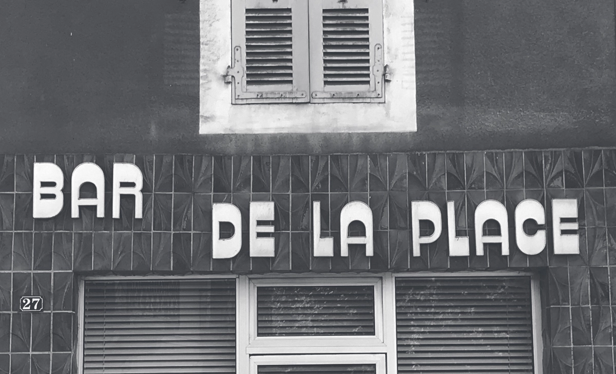 caractères apposés sur un mur, formant le mot bar de la place.